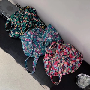 Detailed view of three vintage floral canvas tote bags with diverse flower patterns