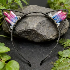 Detail of cat ear headband with pink and blue gradient crystals on a dark grey stone
