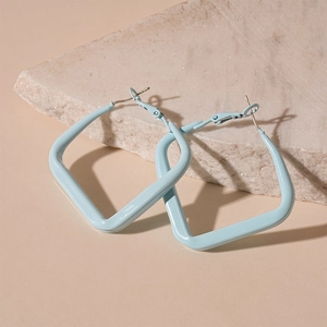 Detail of light blue square hoop earrings with glossy finish on a marble stone base
