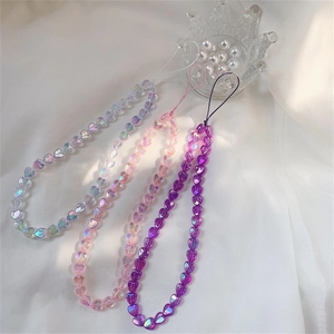 Close-up of three colorful heart-shaped acrylic bead phone charms in iridescent finishes