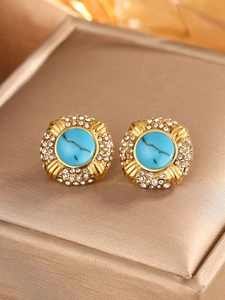 Detailed macro view of vintage round stud earrings with turquoise stone and crystal halo