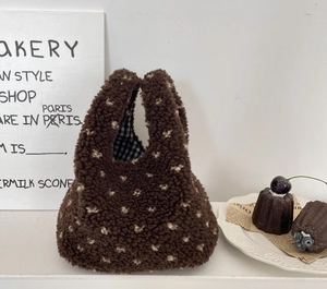 Détail du sac à main en peluche marron à pois blancs avec doublure intérieure à carreaux