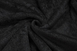 Macro shot of thick black faux fur fabric showing soft plush texture and dense fibers