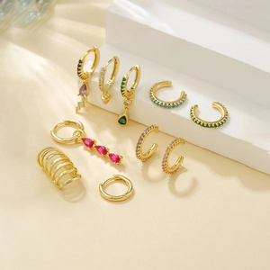 Luxury 9-piece gold-plated earring set with colorful gemstones and zircon on beige steps