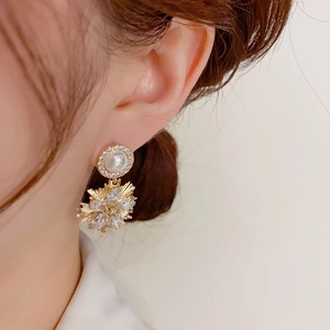Elegant gold fireworks drop earrings with pearls and crystals shown on model