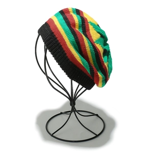 Detail view of handmade crochet Rasta beret with red yellow and green stripes on a stand
