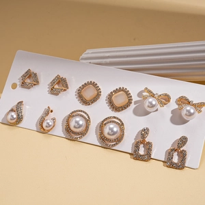 Set of 6 gold earrings with geometric shapes, pearls, and rhinestones on a white card