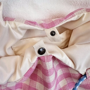 Detail of pink plaid tote bag featuring secure metal magnetic clasp and cotton-linen texture