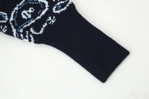 Detailansicht der Rippbündchen und Jacquardmuster auf der blauen Strickjacke