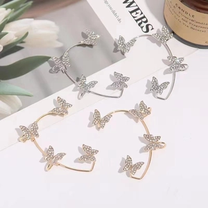 Vue détaillée de boucles d'oreilles papillon avec strass brillants sur un décor esthétique