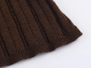 Macro shot of coffee brown ribbed knit fabric texture showing fine stitching and fibers