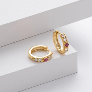Macro detail of S925 sterling silver hoop earrings with red gemstone and zircon inlay