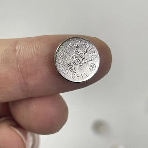 Detail view of CR1130 lithium button cell battery with crown logo and silver finish