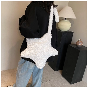 Detail of white plush star-shaped crossbody bag with wide shoulder strap on model