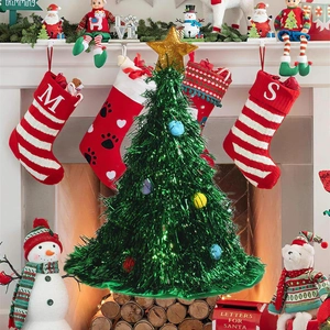 Detail of green tinsel Christmas tree hat with gold star and colorful bauble decor