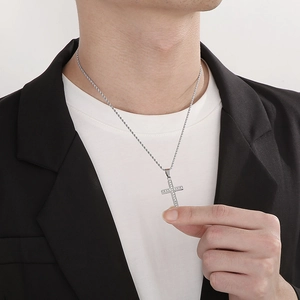 Minimalist silver stainless steel cross necklace with diamonds on a male model in a suit
