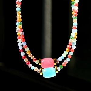 Detailed close-up of colorful rhodochrosite beaded necklace with golden metal spacers