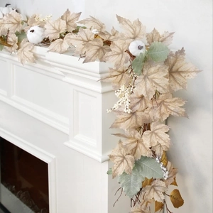 Thanksgiving garland with white pumpkins, maple leaves, and berries on a white fireplace
