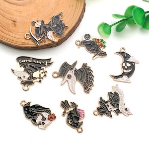 Macro detail of Halloween plague doctor and raven enamel charms on wood base