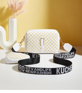 Close-up of white camera bag with geometric print, wide strap and small coin purse attachment