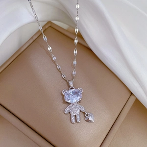 Detailed close-up of a silver teddy bear pendant with crystal inlay and heart charm