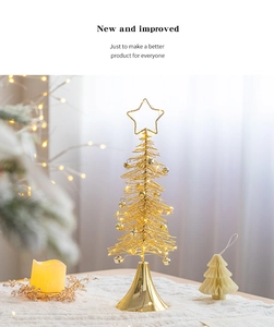 Detail of a gold wire Christmas tree tabletop ornament with warm LED lights and bells