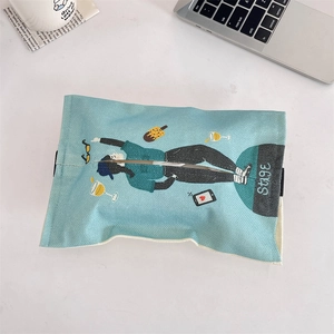Close-up of light blue fabric tissue box with cartoon illustrations on a desk
