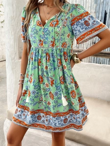 Detailed view of V-neck short sleeve dress with green floral prints and buttoned front