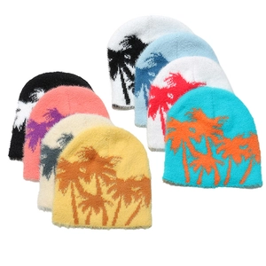 Plush winter beanies with jacquard palm tree patterns in multiple colors on white background