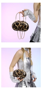 Detail view of leopard print handbag showing golden chain strap and handheld carrying style