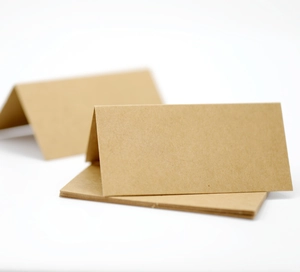 Close-up of brown kraft paper place card with natural fiber texture and V-fold design