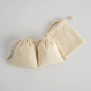 Detailed texture of beige drawstring jewelry pouch with natural linen cotton fabric grain