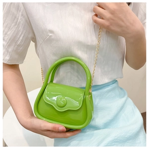 Close-up of vibrant lime green jelly mini bag with fine gold chain and glossy finish