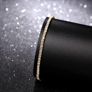 Macro view of a 2.0mm gold-plated stretch bracelet with single row sparkling rhinestones