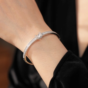 Detail of silver bangle with pavé-set diamonds and a large round centerpiece stone
