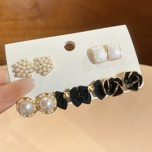 Détail du lot de barrettes élégantes avec perles et roses noires sur carte de support