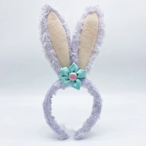 Detail of plush purple rabbit ear headband with green satin flower and pink button accent