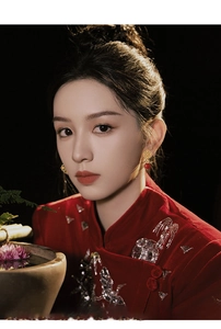 Detail of hollowed floral gold earrings with red beads on a model in vintage Chinese style