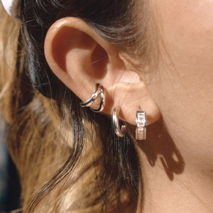Set of minimalist stainless steel rhinestone hoop earrings and ear cuffs on female model
