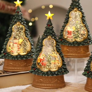 Macro shot of illuminated Christmas tree music box with Santa and glowing star topper