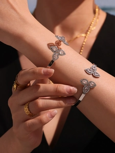 Close-up of silver butterfly open bangle with pavé zircons and polished metallic finish