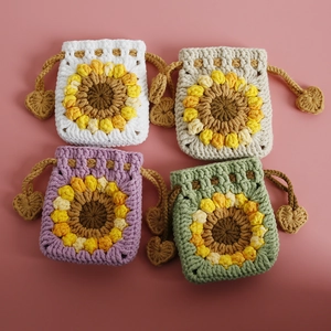 Handmade crochet sunflower drawstring coin pouches in four pastel colors on pink background