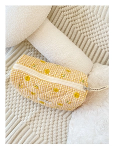 Détail d'une trousse à maquillage matelassée avec motif smiley jaune et cerises