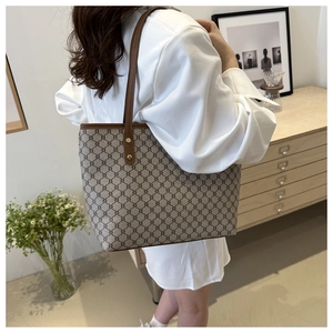 Close-up of retro brown tote bag with geometric pattern and leather straps