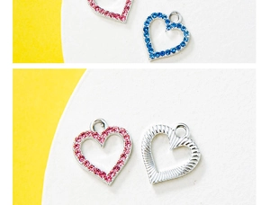 Macro detail of heart-shaped DIY charms with pink and blue rhinestones and silver texture