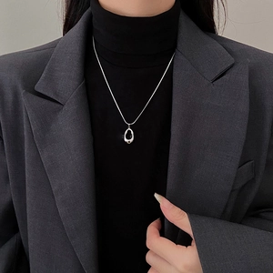Silver hollow geometric pendant necklace worn by a model in a minimalist style