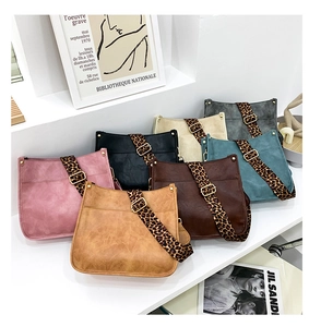 Detail of colorful crossbody bags with trendy leopard print straps and gold metal buckles