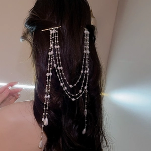 Detail of long multi-layer pearl tassel hair clip worn on the back of long hair