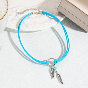 Detail of bohemian turquoise choker with double suede cords and silver feather pendants