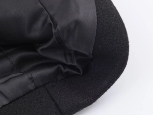 Detailed macro view of the soft black fabric texture and smooth inner lining of the coat